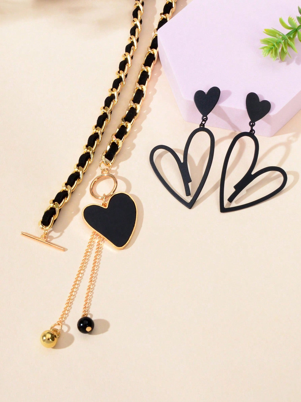 Black heart pendant necklace and matching earrings set crafted from polished metal with dark centerpieces. — view 4