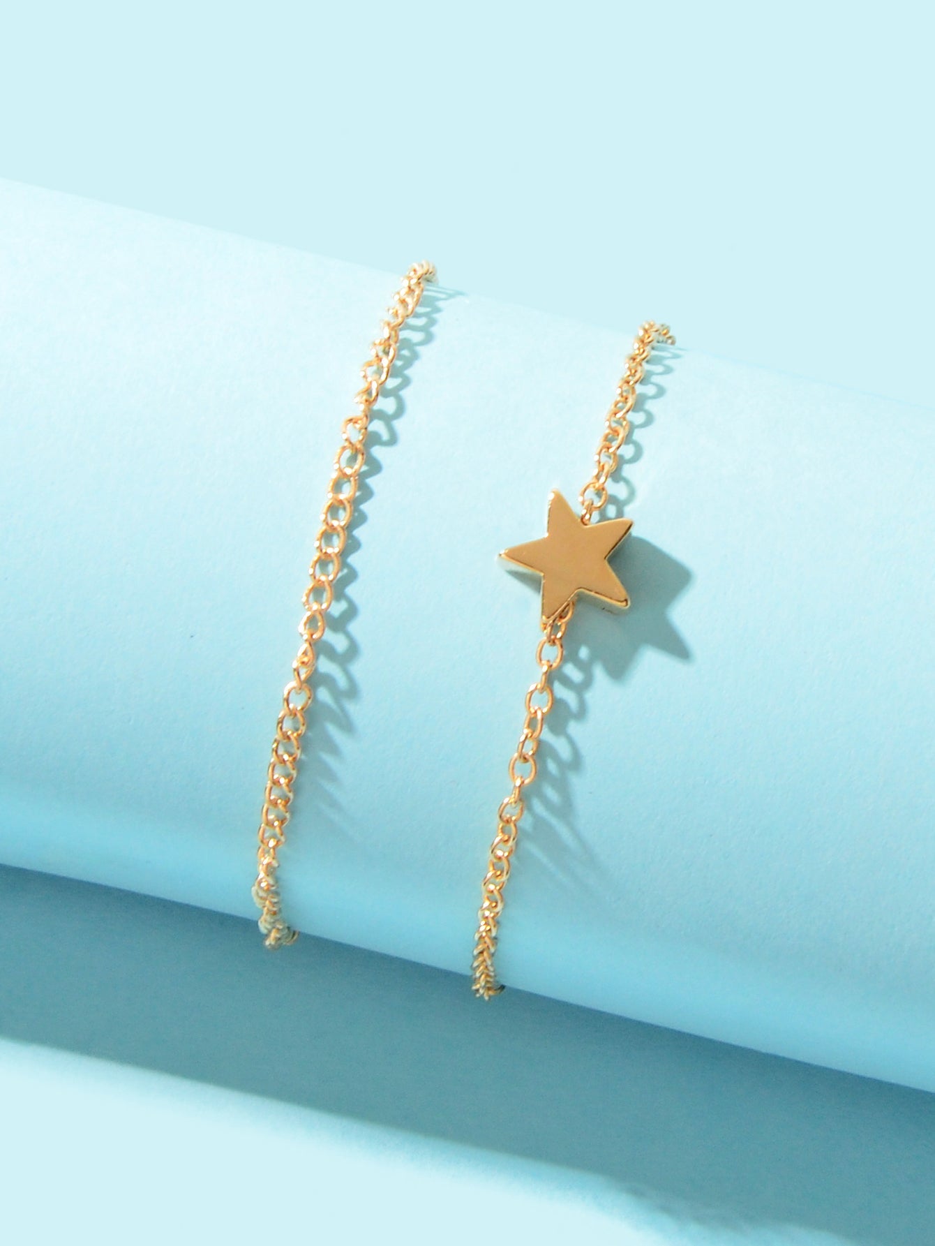 Minimalist double layered gold chain anklet featuring delicate star charms on a plain background — view 3