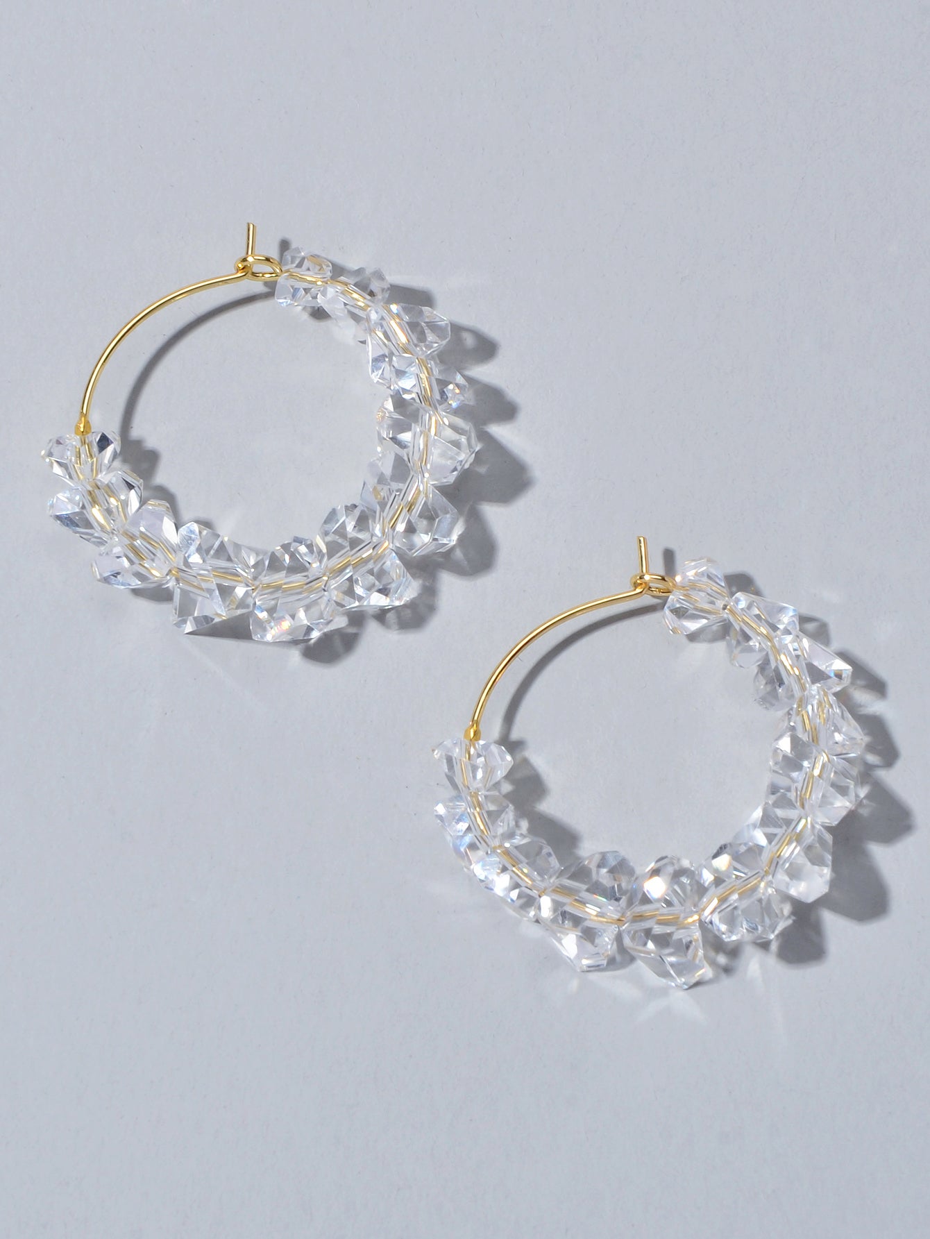 Transparent acrylic bead hoop dangle earrings for women on a clean background. — view 3