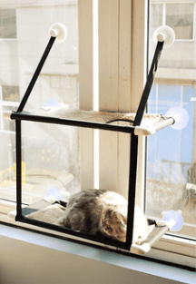 Window sill cat hammock in neutral coral velvet mounted to a glass window with suction cups — view 3