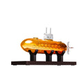 Submarine shaped whiskey decanter made of borosilicate crystal glass on a smooth wooden base.
