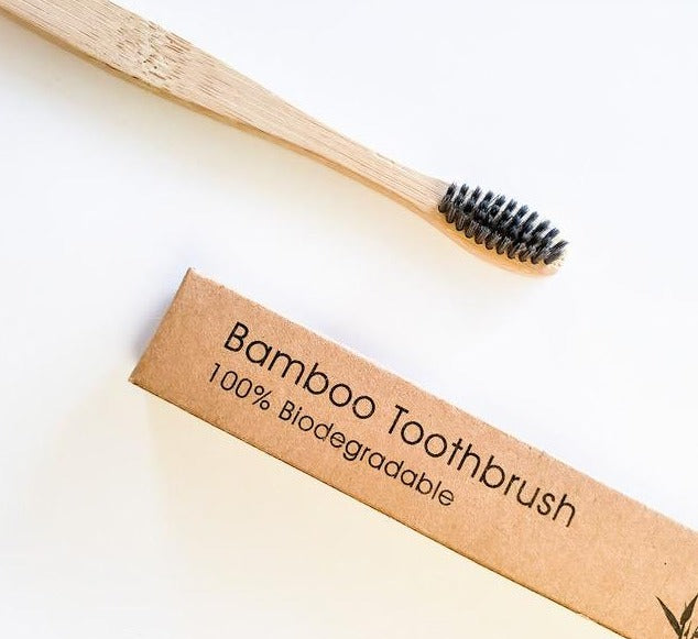 Bamboo charcoal toothbrush with black soft bristles and natural wooden handle on a clean background — view 3
