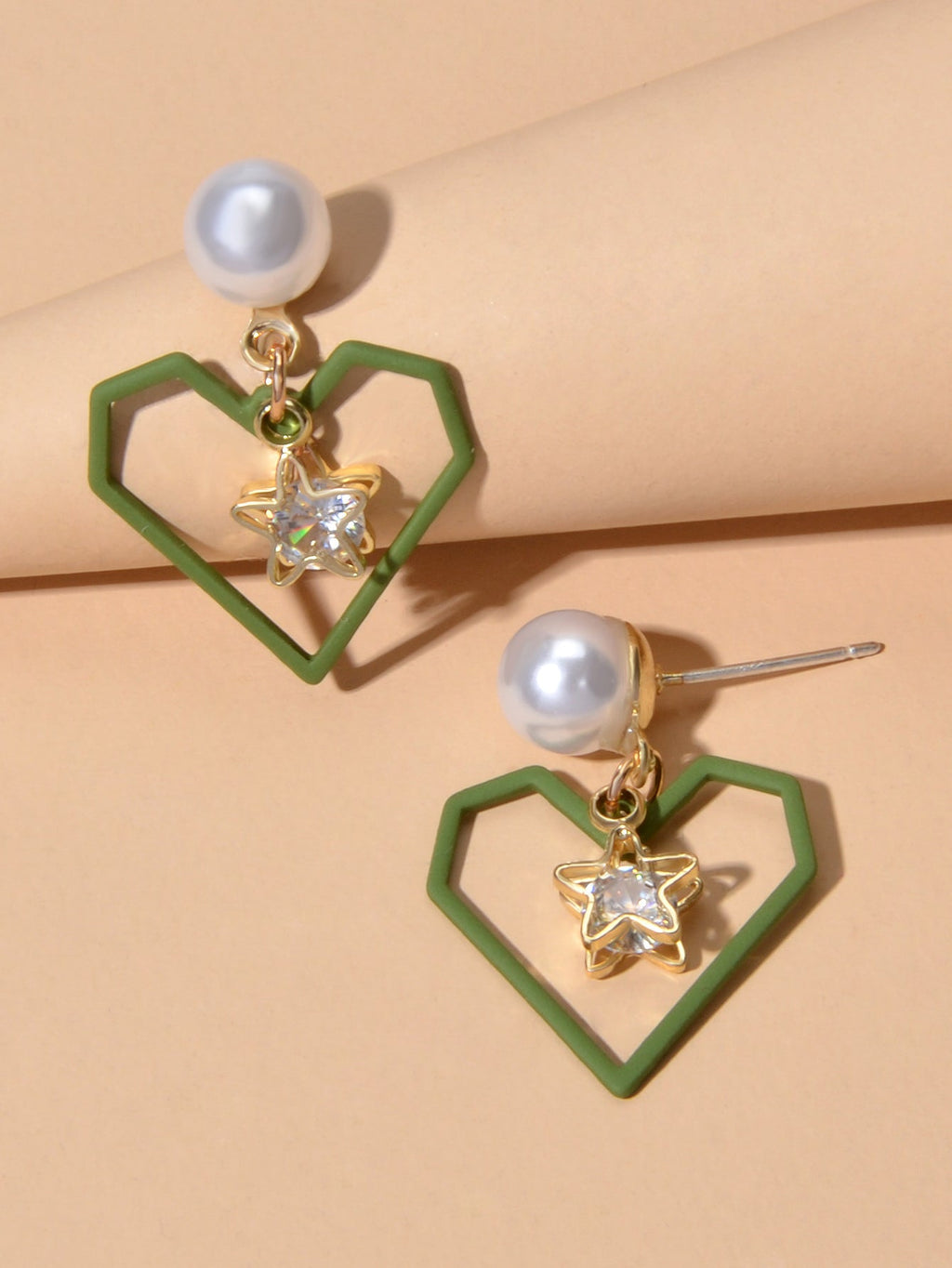 Gold tone dangle earrings featuring rhinestone star and pearl heart decorations on a white background — view 4