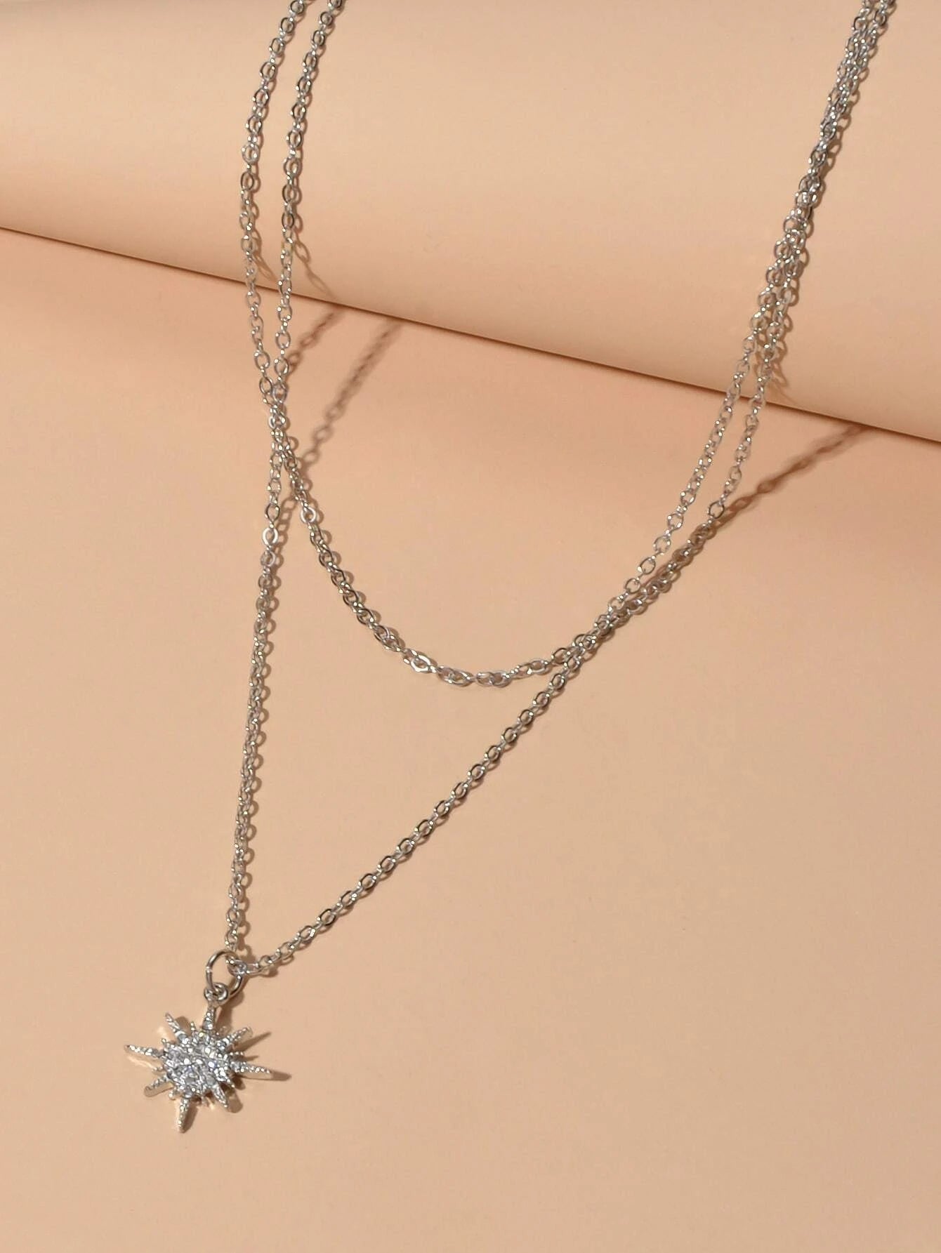 Silver double layer star pendant necklace and five matching knuckle rings displayed together as a set — view 4
