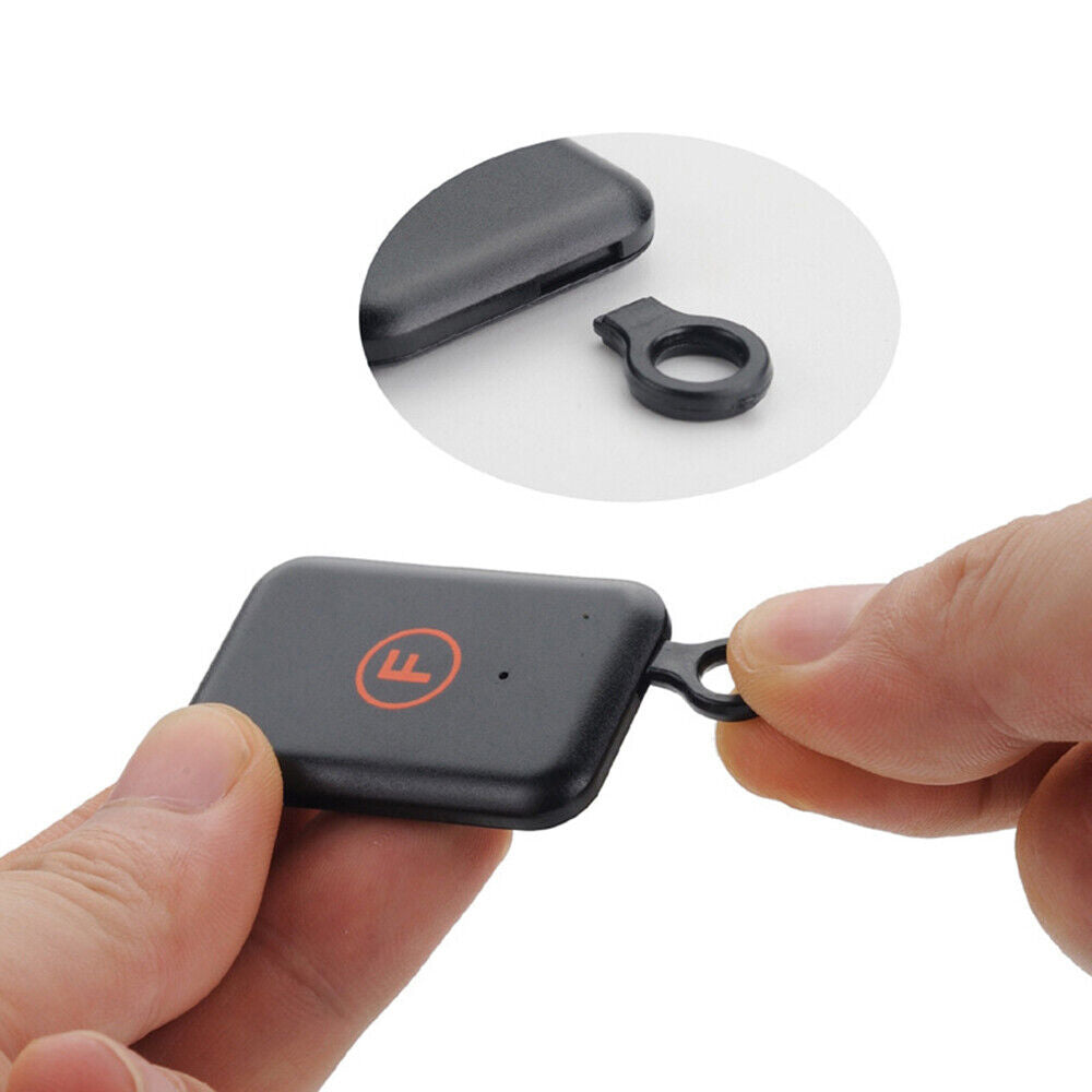 Wireless key finder set showing one black remote transmitter and six small tracker receivers — view 5