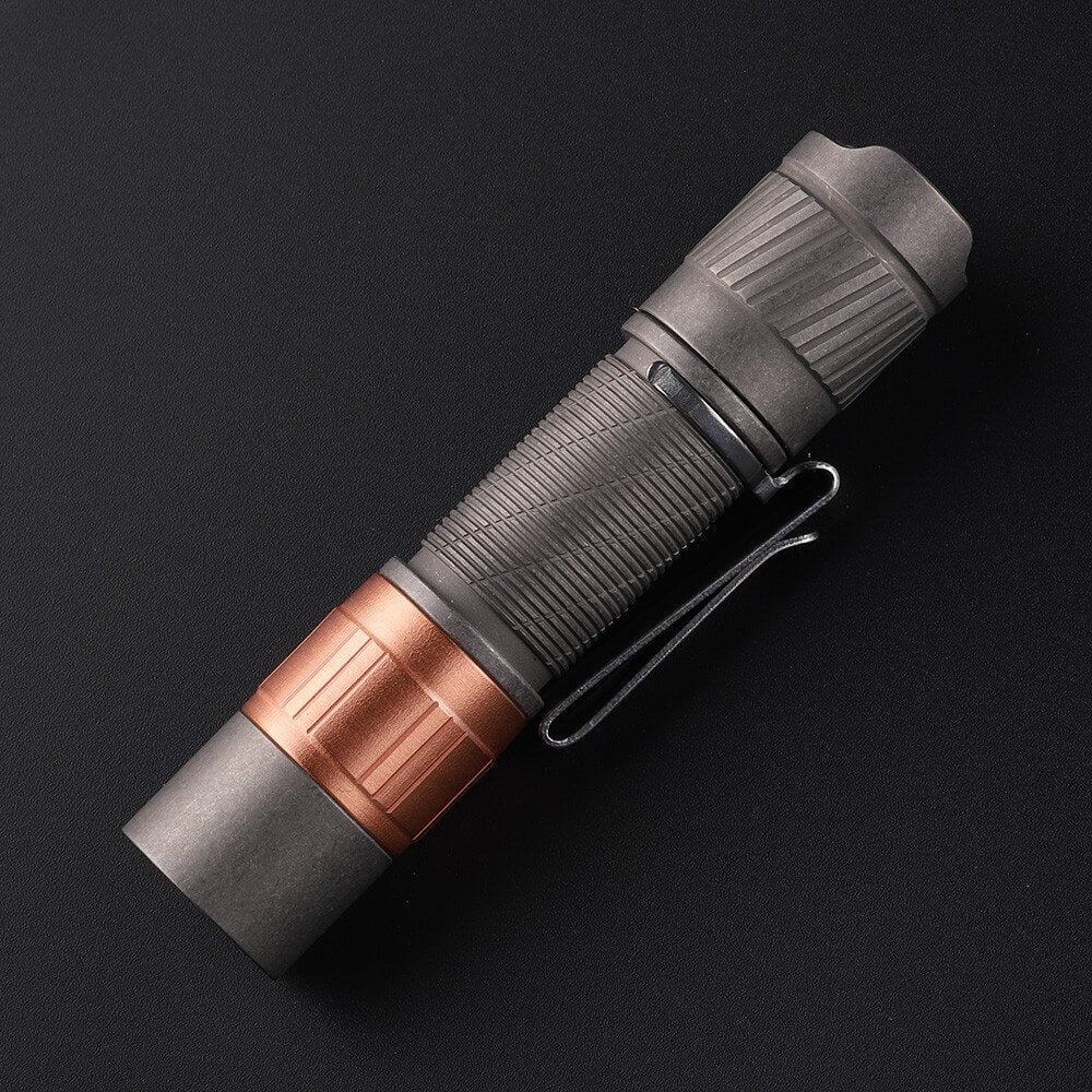 Compact titanium everyday carry flashlight with a metallic finish and tactical tail switch button — view 5