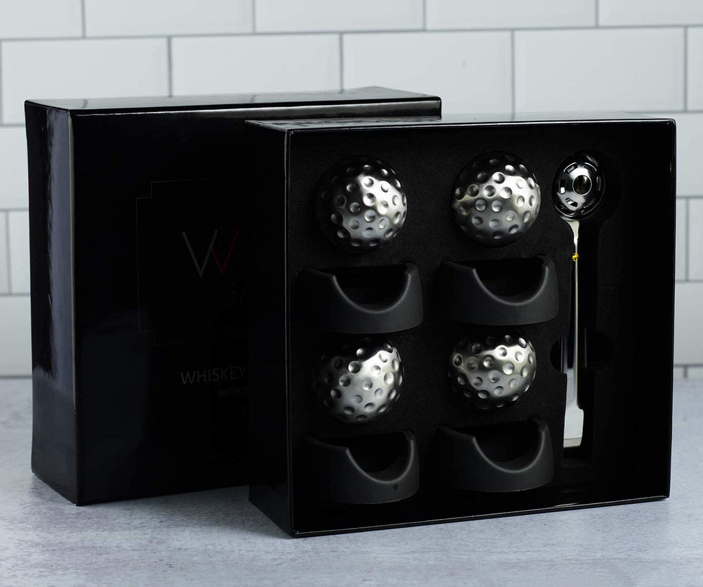 Stainless steel golf ball shaped whiskey stones chilling in a crystal glass of bourbon — view 3