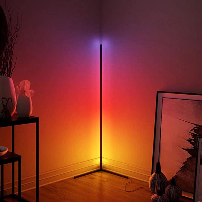 Black minimalist RGB corner floor lamp illuminating a living room with vibrant multicolored LED lighting — view 2
