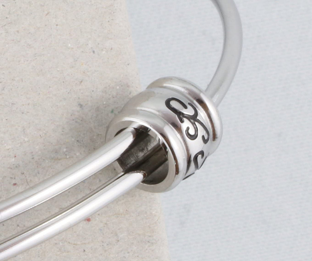 Silver stainless steel adjustable bangle bracelet featuring a detailed sneaker baby shoe charm. — view 2