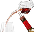 Clear Italian wine aerator decanter pouring red wine directly from the bottle to a glass