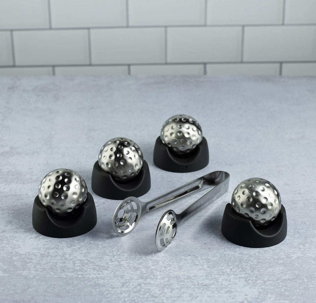 Stainless steel golf ball shaped whiskey stones chilling in a crystal glass of bourbon — view 4