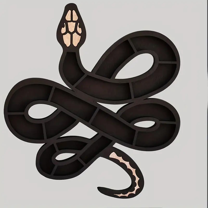 Black wooden snake shaped wall shelf displaying crystals and small plants on a wall — view 3