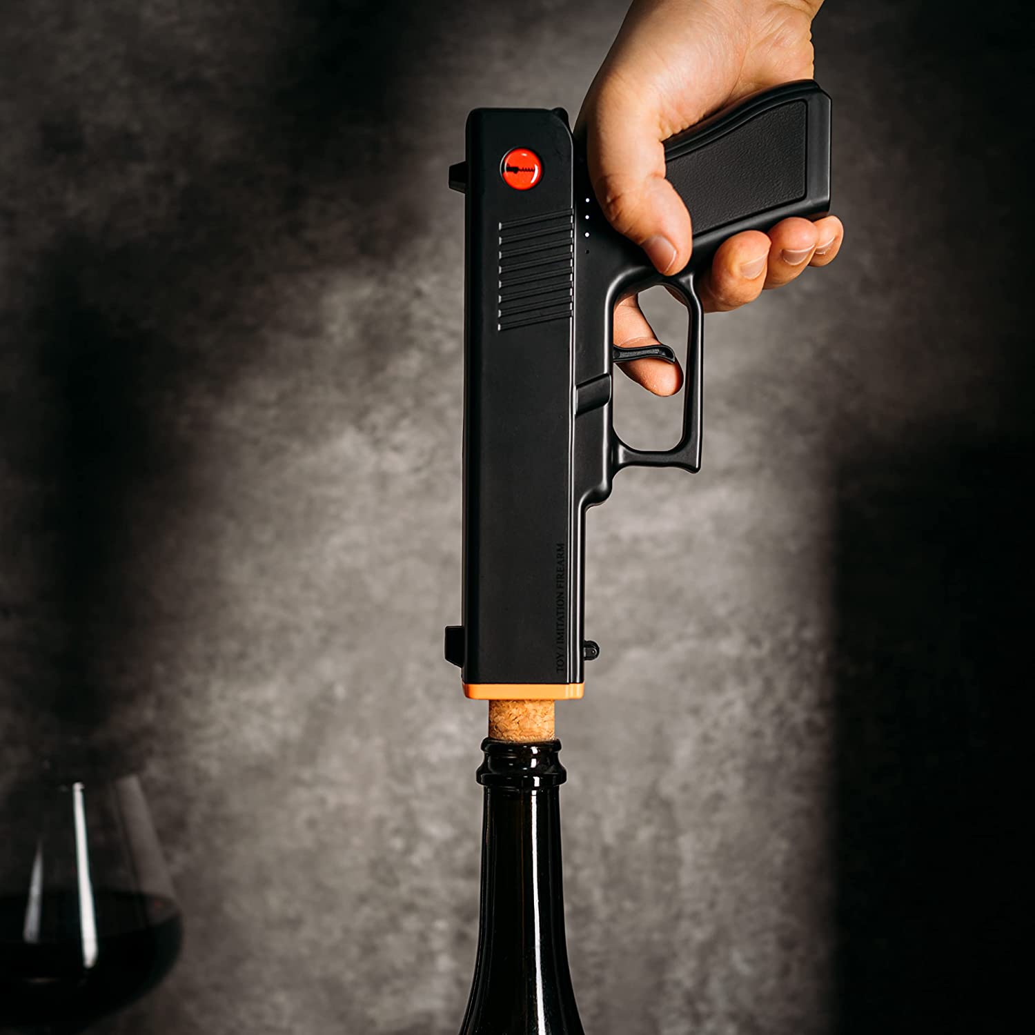 Black electric pistol shaped wine bottle opener resting in its rechargeable holster base. — view 3