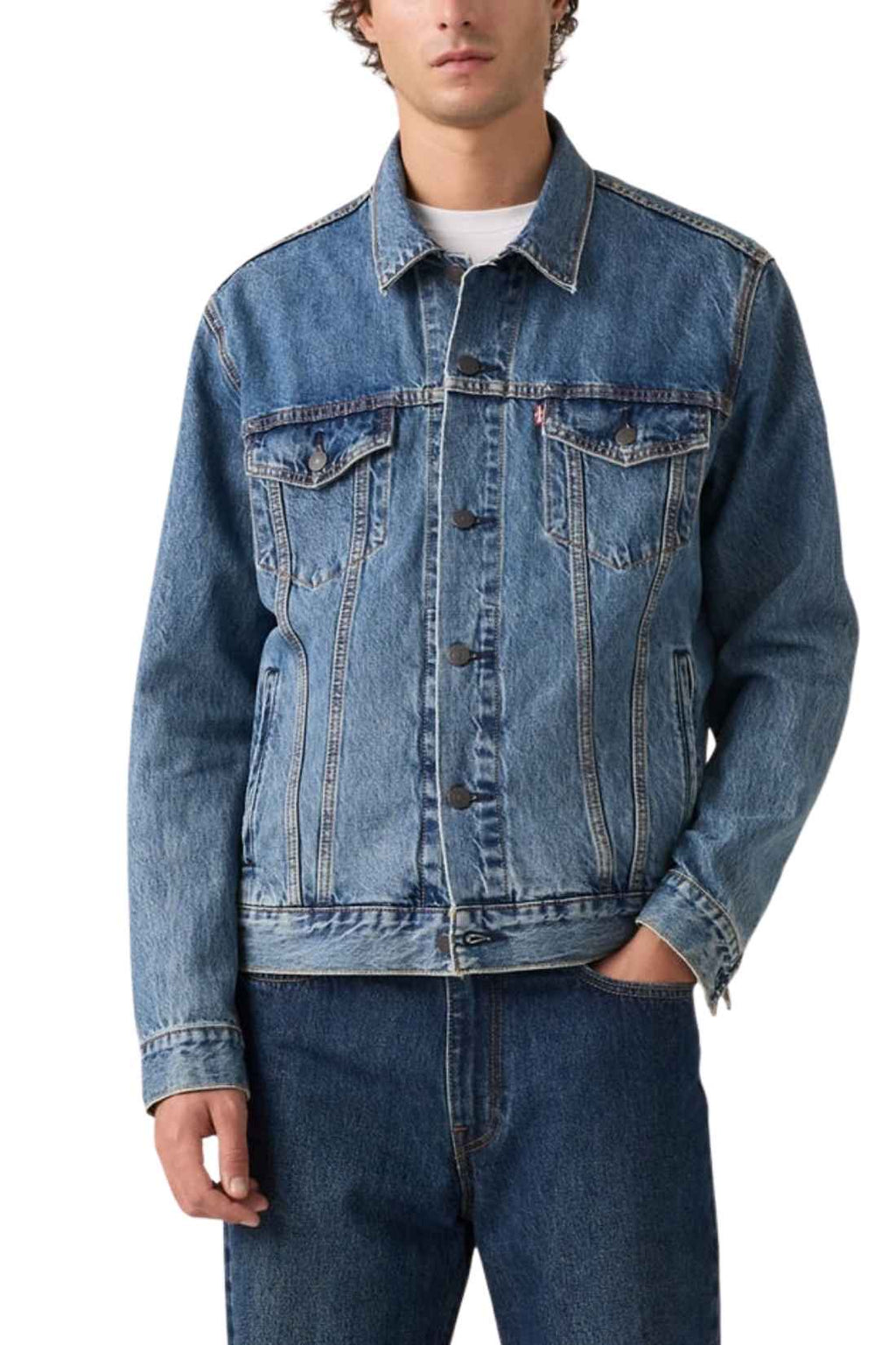 Men's classic medium wash denim trucker jacket featuring front logo buttons and chest flap pockets. — view 13