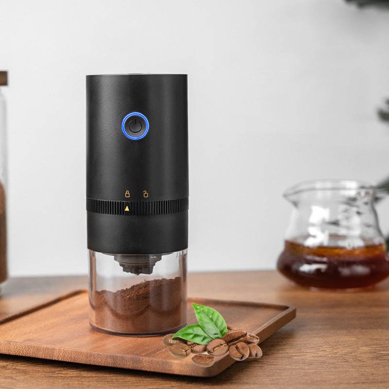 Portable electric coffee grinder with ceramic burr mechanism transparent chamber and sleek modern travel design