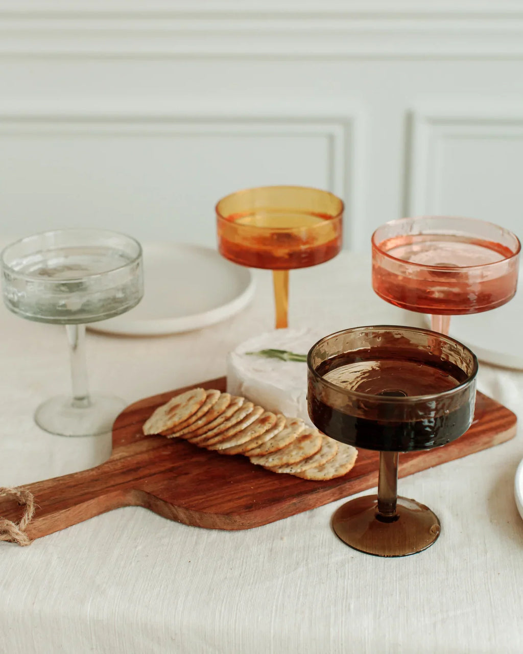 Handblown hammered coupe cocktail glasses pair in colored recycled glass on a table — view 5