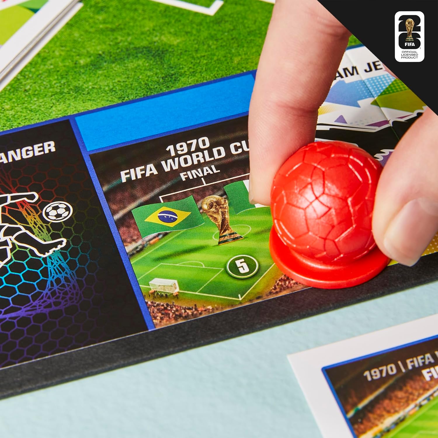 Monopoly FIFA board game box with football trading cards, dice, and player tokens on display — view 5