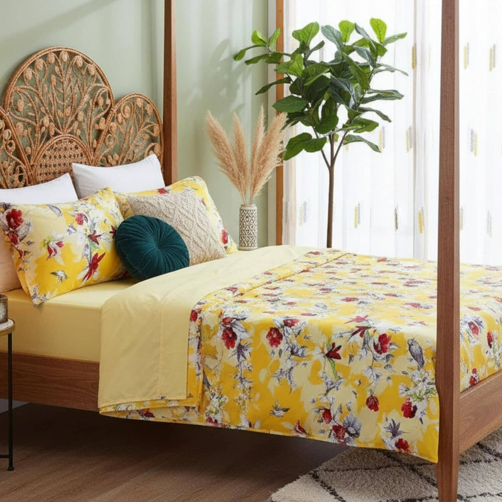Sunshine yellow floral and hummingbird patterned bed sheets set with pillowcases on a comfortable mattress