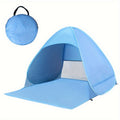 Portable waterproof beach tent in blue with sunshade pitched outdoors on sand