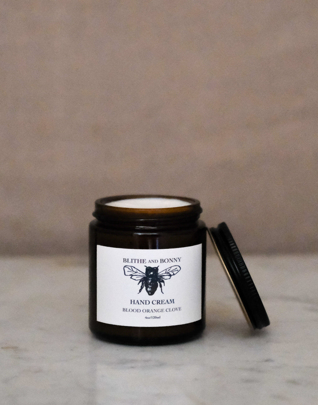 Luxurious vegan hand cream in a four ounce amber glass jar with a metal lid