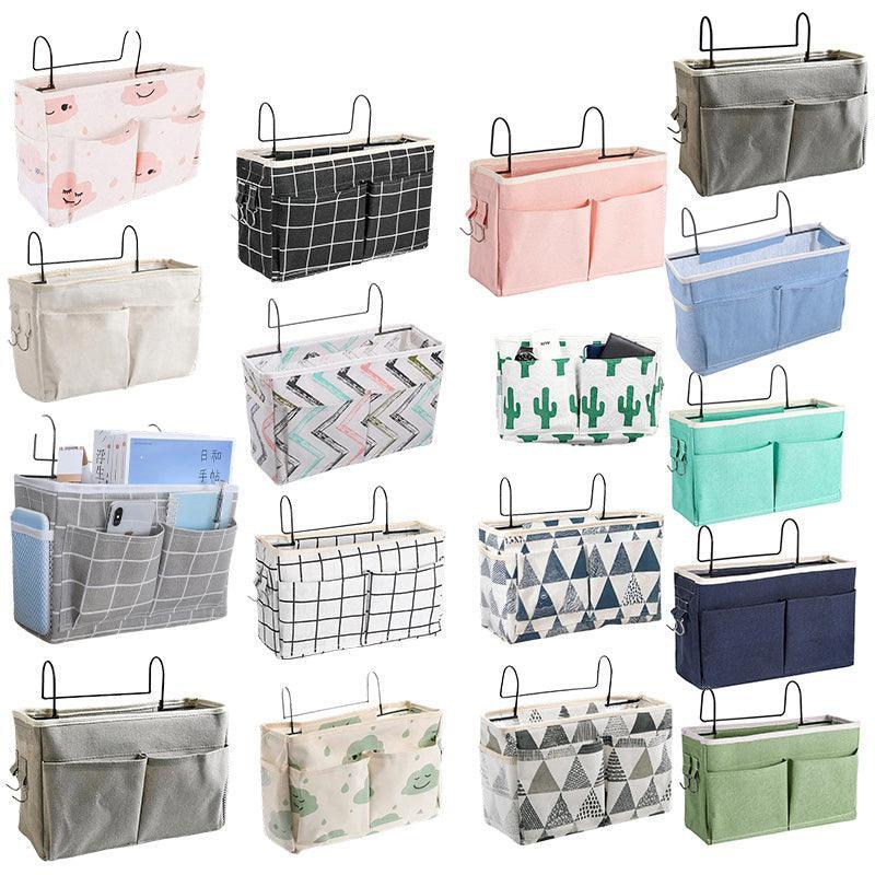 Canvas bedside storage caddy hanging on a bed frame holding books and remote controls — view 2