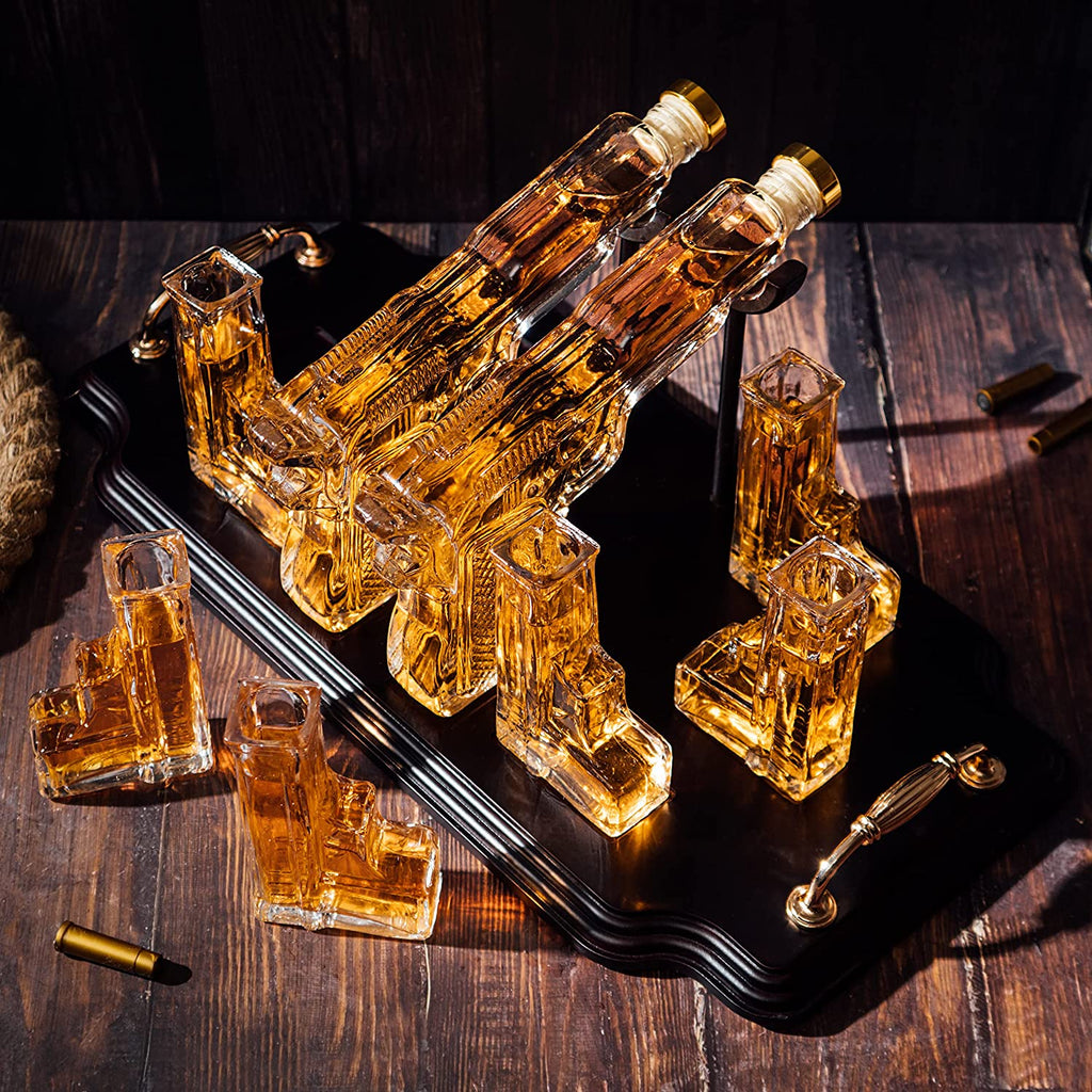 Double pistol whiskey decanter set with six shot glasses on a wooden display stand — view 2