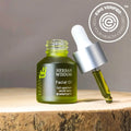 Herban Wisdom facial oil in half size dropper bottle, featuring botanical extracts for glowing skincare.
