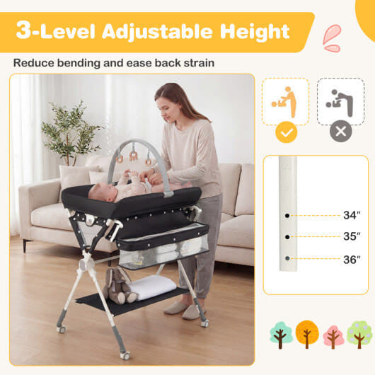 Black foldable baby changing table station with storage bag, bottom shelf, and wheels. — view 4