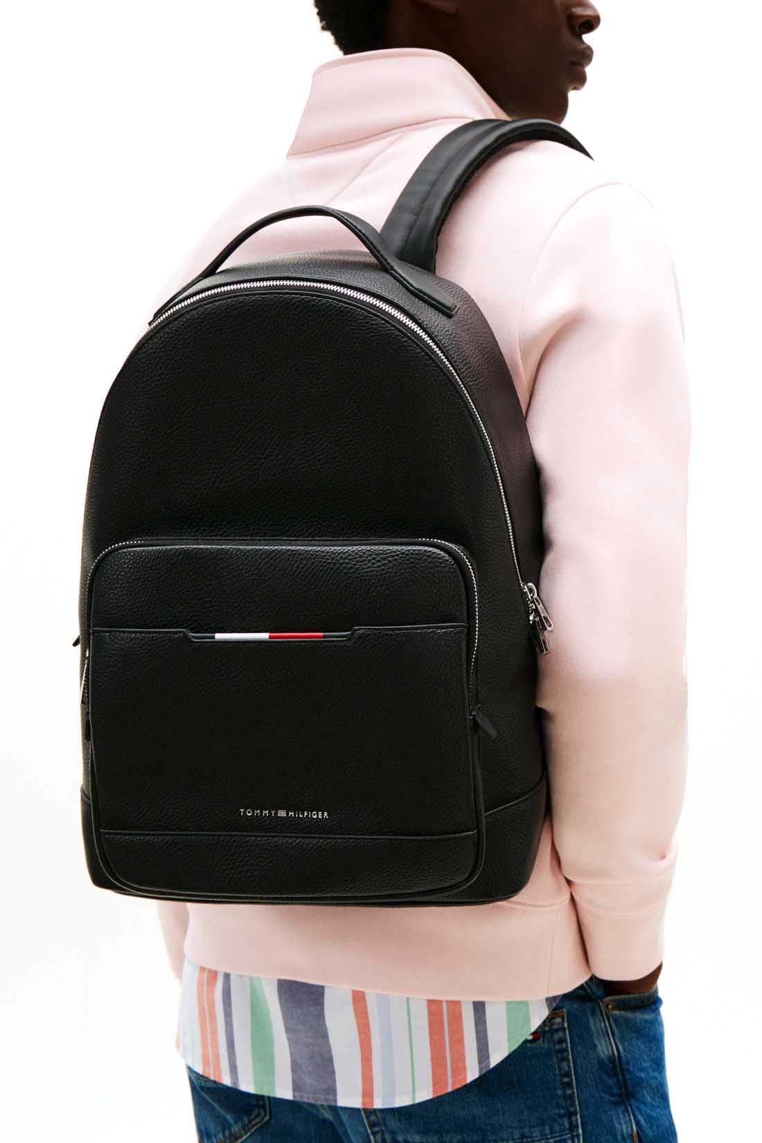Men's black grained faux-leather backpack with double zip, front pockets, and metal logo detailing — view 4