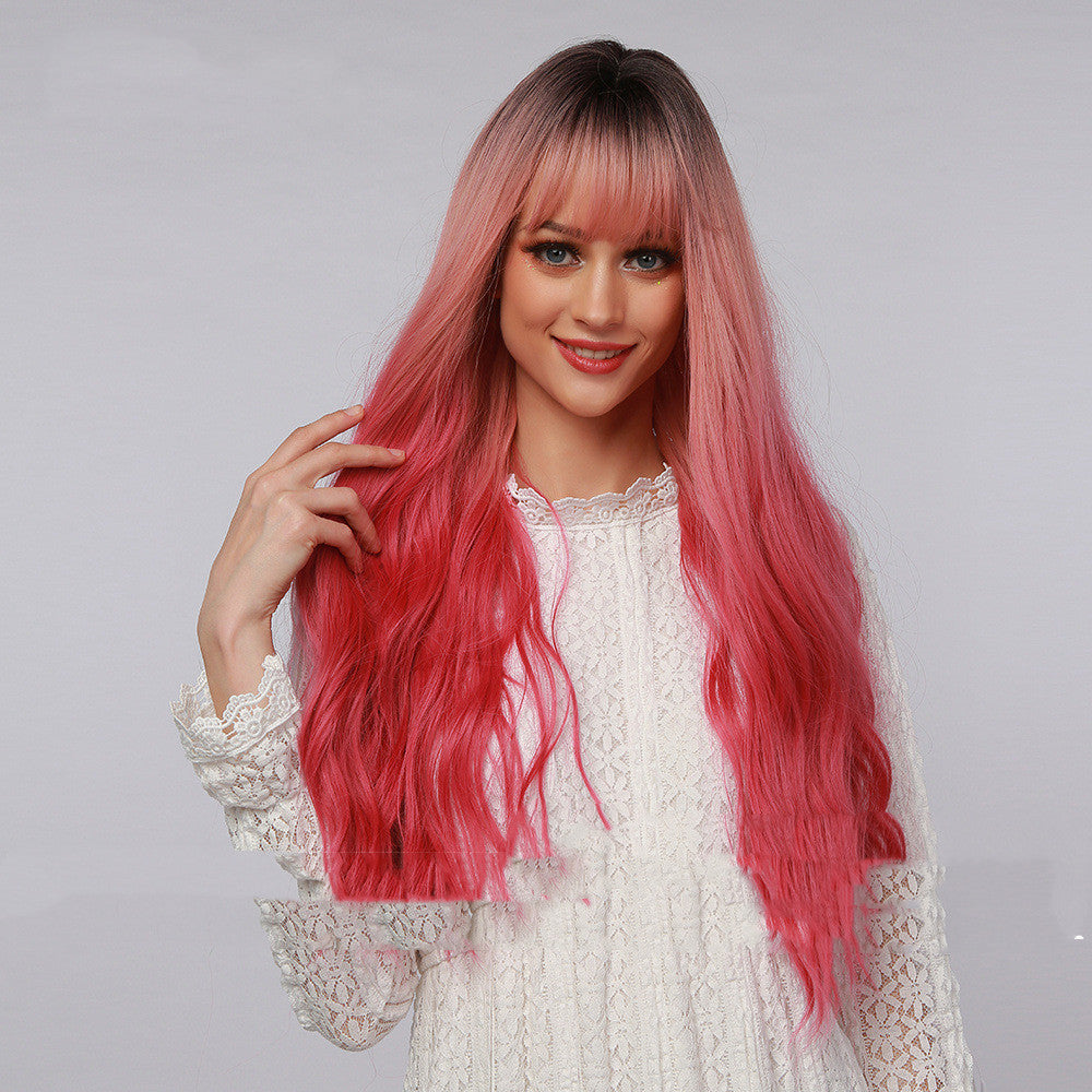 Long curly synthetic wig with straight bangs in black to strawberry pink ombre gradient — view 2