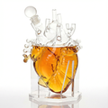 Transparent borosilicate glass anatomical heart decanter for whiskey or wine on a table.