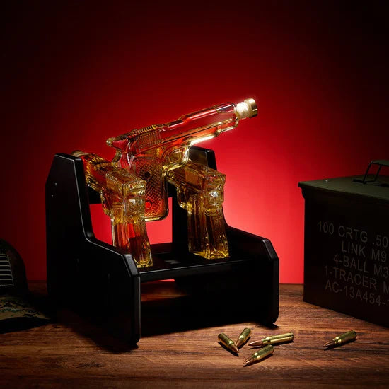 3-pistol whiskey decanter set made of glass resting on a rich mahogany wood display base — view 3