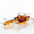 Clear glass F1 racecar whiskey decanter holding liquor on a wooden bar cart