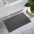 Dark gray plush washable bath mat made of soft polyester shag for modern bathroom floors