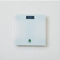 Sleek tempered glass digital bathroom scale with a clear LCD display reading precise weight measurements