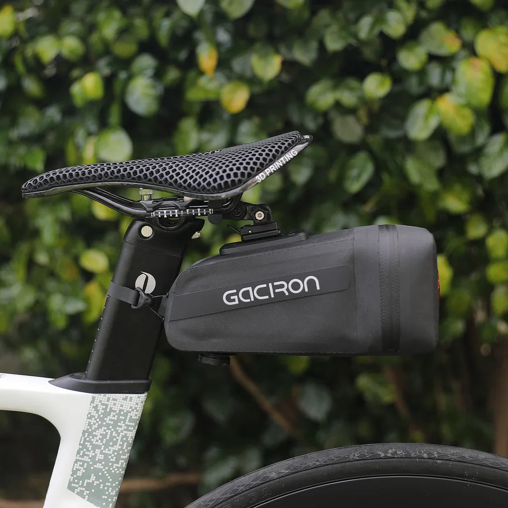 Black waterproof bicycle saddle bag with integrated smart taillight mounted securely under a bike seat — view 5