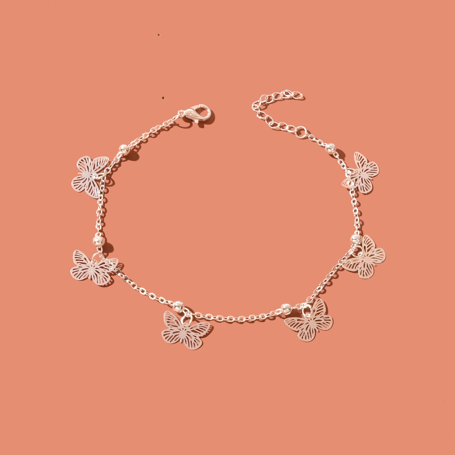 Silver-tone butterfly charm anklet chain displayed as delicate boho beach foot jewellery. — view 2