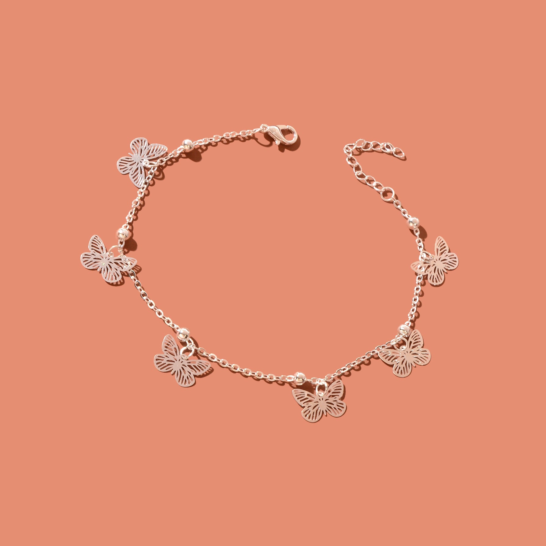 Silver-tone butterfly charm anklet chain displayed as delicate boho beach foot jewellery. — view 3