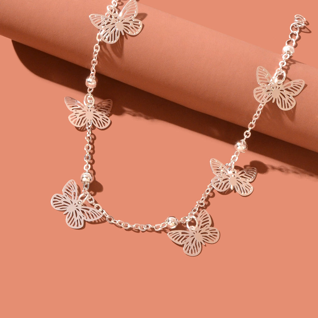 Silver-tone butterfly charm anklet chain displayed as delicate boho beach foot jewellery. — view 5