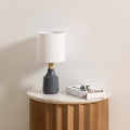 Contemporary Buharkent table lamp featuring a translucent gray resin base and white linen drum shade.