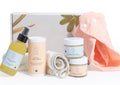 Organic baby skincare gift set in beautiful box featuring balms, oils, powder, and soft bibs