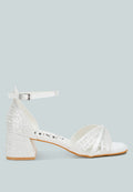 White satin low block heel sandals featuring elegant pearl embellished midfoot straps and adjustable buckles