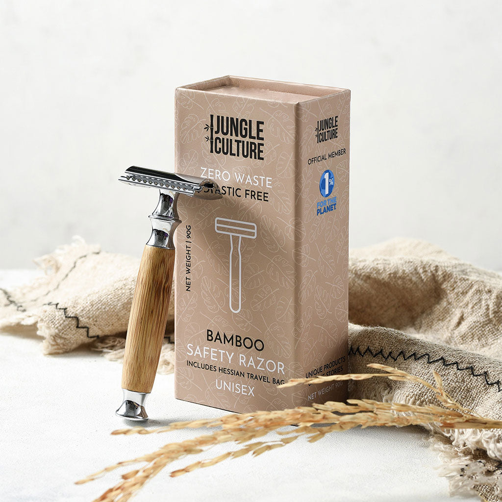 Reusable bamboo safety razor with long wooden handle and stainless steel head alongside kraft packaging — view 2