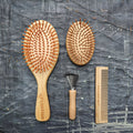 All-in-one bamboo hair brush set including paddle brush, travel brush, comb, and brush cleaner tool
