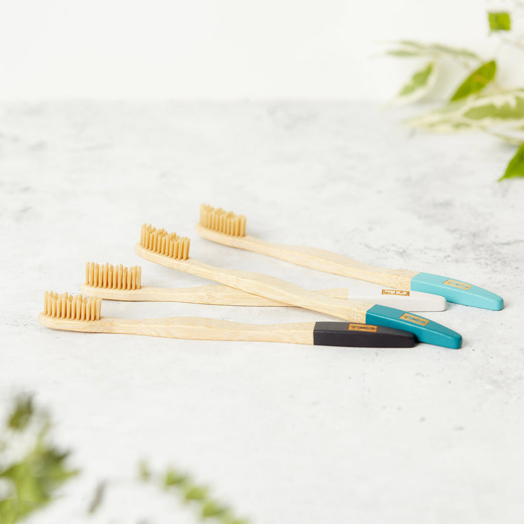 Set of four natural bamboo toothbrushes with soft bristles in zero waste kraft paper packaging — view 2