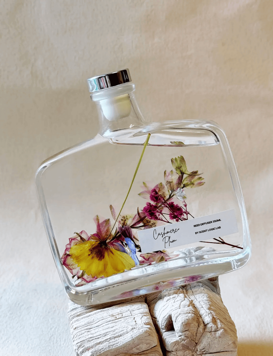 Handmade botanical reed diffuser in a clear minimalist glass bottle with natural rattan reeds — view 4