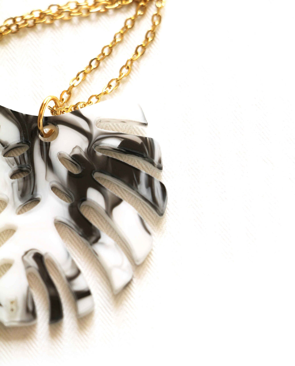 Collar dorado hoja monstera en blanco y negro-3