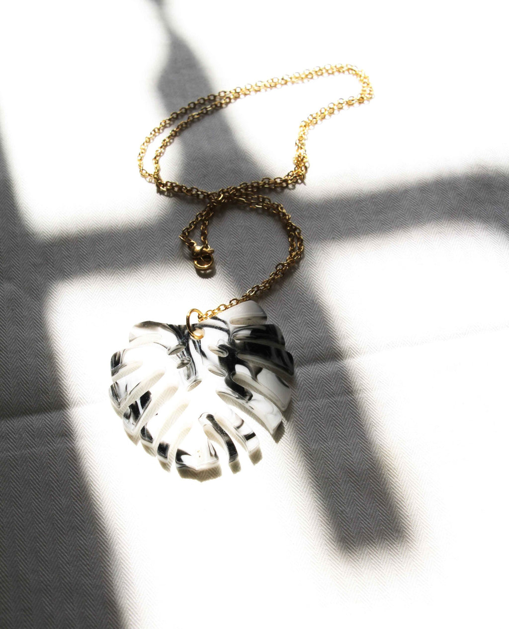 Collar dorado hoja monstera en blanco y negro-2