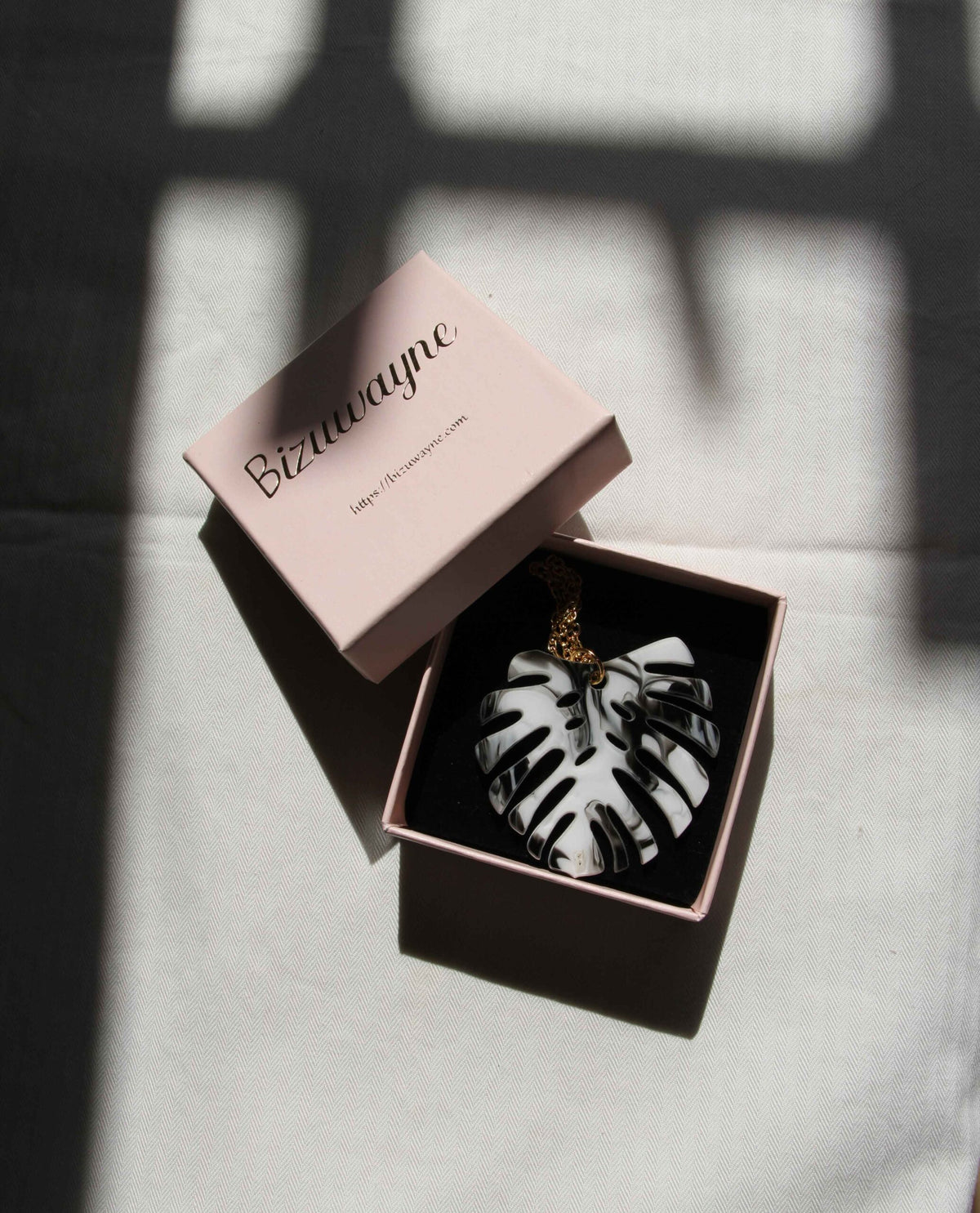 Collar dorado hoja monstera en blanco y negro-1