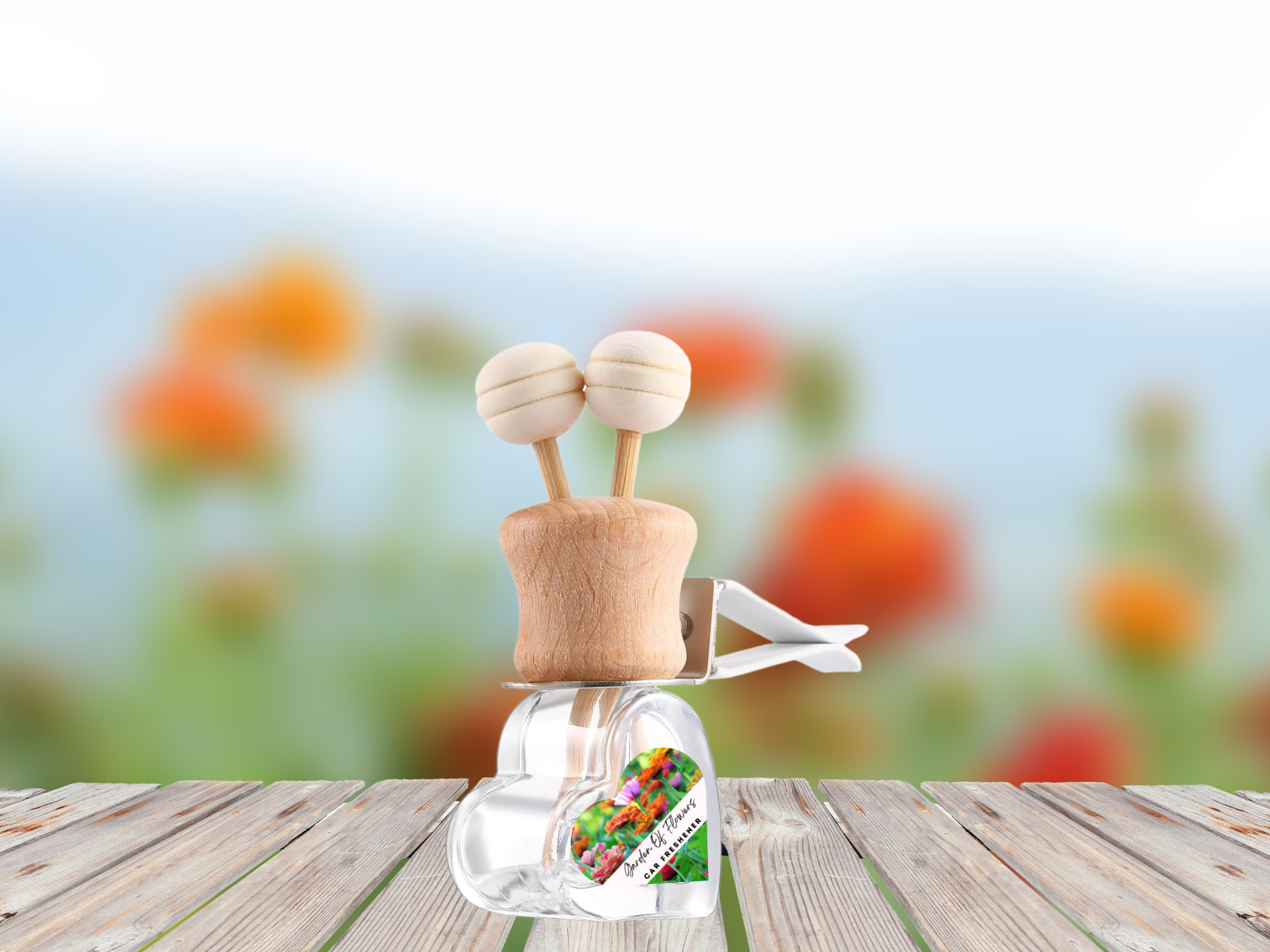 Floral vent car diffuser in sleek glass bottle with wooden reed sticks and sturdy mounting clip